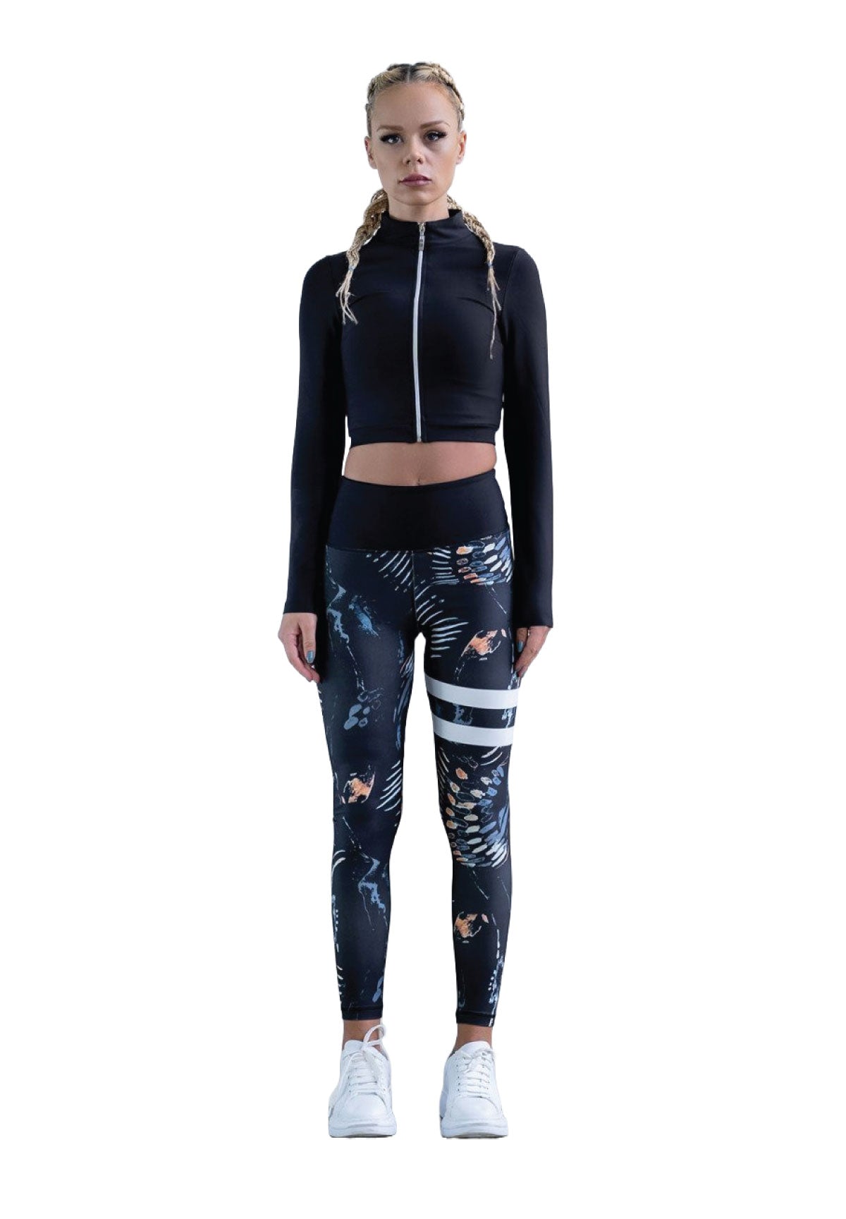 Frau in schwarzer Kurzjacke, Zopffrisur und gestreiften Lismina-Leggings mit hoher Taille vor weißem Hintergrund.
